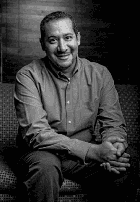 black and white photo of ray rico seated